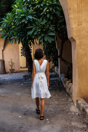 Tourist on vacation. A woman enjoys sightseeing in the city on vacation. A girl in a white dress walks along the streets of the old city. travel and vacation.の写真素材