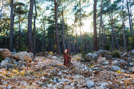 young beautiful woman walks through the forest in a beautiful dress. Concept of balance, harmony and health. girl alone with nature.の写真素材