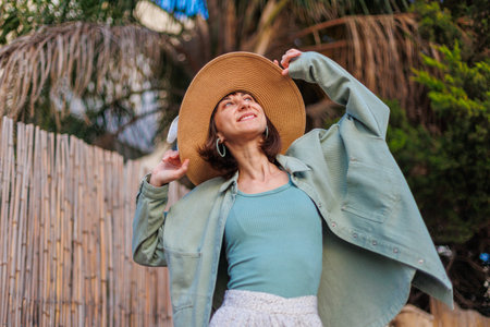 Close-up portrait of a beautiful traveling brunette woman wearing a hat, stylish summer clothes....