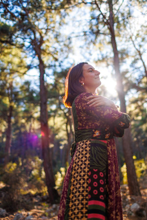 Concept of balance, harmony and health. girl alone with nature. a girl dances and sings in the forest among the trees. young and beautiful girl among natural landscapes.の写真素材