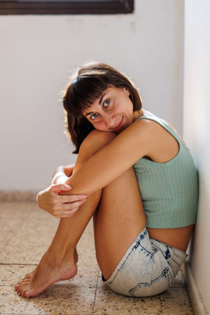 Portrait of a young girl with black short hair in a bright room. Close-up of a carefree young woman....