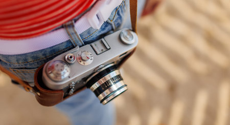 Close-up of a film camera. a young girl in stylish clothes takes photographs with a film camera....