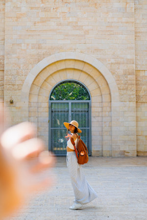 Follow me and travel together. Happy smiling joyful young girl traveler. a girl extends her hand to her boyfriend during a weekend vacation while sightseeing. young girl travels.の写真素材