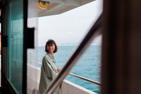 girl stands on the deck of a cruise ship. The girl is traveling. A young beautiful brunette travels...