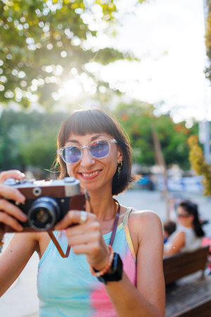 girl walks around the city and takes pictures with a camera. Close-up of a film camera. Traveler,...