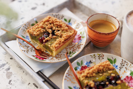 dessert and coffee for two. nut cake with pieces of pistachios and coffee on the table in an...