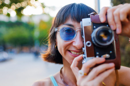 girl walks around the city and takes pictures with a camera. Close-up of a film camera. Traveler,...