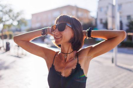 girl in stylish clothes enjoys a walk in the city. young cheerful woman smiling. walk on a summer day.の写真素材
