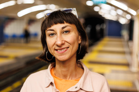 Portrait of a young girl. Face of a young girl in glasses close-up. The girl is standing at a metro...
