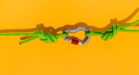 two ropes with secure knots are connected by a carabiner. Equipment for rock climbing and mountaineering. reliable connection. Safety rope. concept of reliability and strength.の写真素材