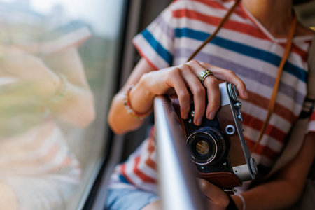 train trip. girl photographer Young girl in stylish clothes enjoying the train trip and taking...