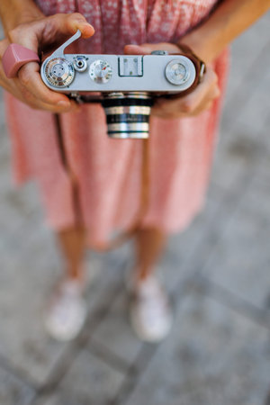 young girl with a camera. the photographer adjusts the camera. Fashionable woman with an analog film...