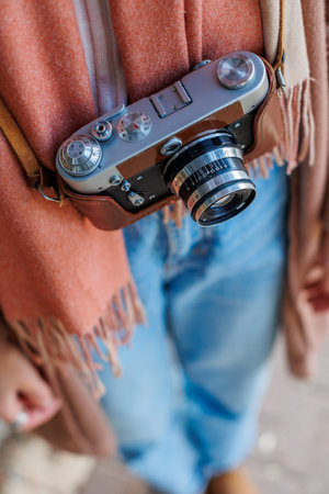 girl with a camera while walking. fashion and style. hipster girl takes pictures with a film camera....