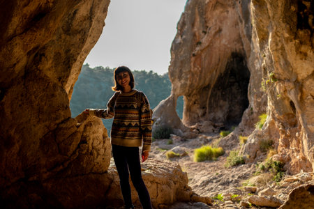A young traveler with a backpack explores the caves. excursion to the cave. girl travels with a backpack. travel and hiking.の写真素材