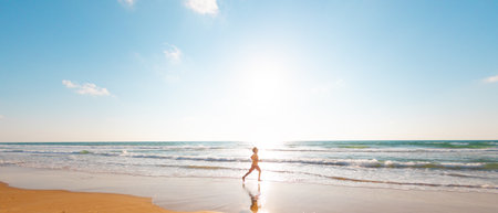 man runs along the sandy beach. fitness training on a sunny summer day. running on the beach. sport and health.の写真素材