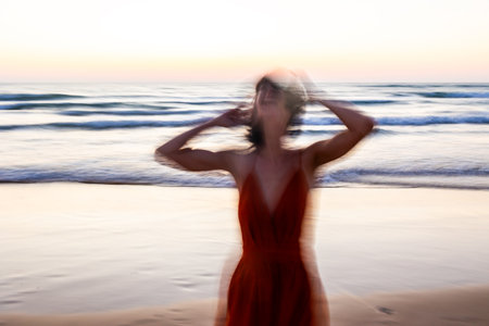 Happy woman walking on the beach. soft focus and long shutter speed. Blurred motion. Summer mood.の写真素材