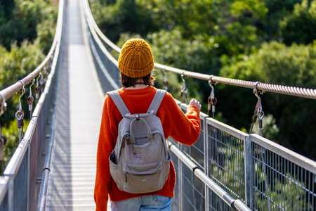 attractive happy young girl in stylish clothes with a backpack on a hike. a girl with a backpack...