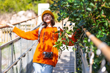 stylish young woman with a backpack travels in sunny weather. Happy female tourist enjoying her trip. Girl with a backpack. travel and adventure.の写真素材
