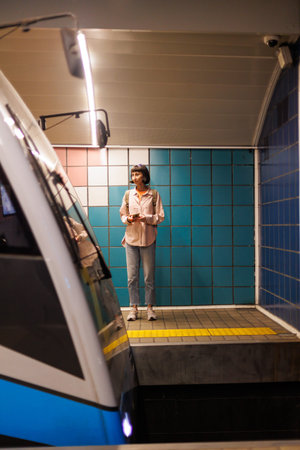 Young woman waiting for a train at the station. wait for a train. girl in the subway. Young girl in...