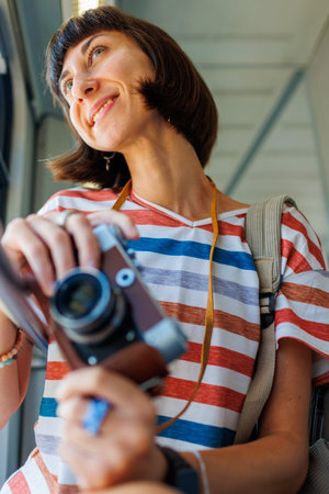 train ride. young woman enjoying train ride and holding camera. camera close up. girl using film...