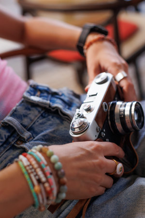 Girl walking around the city and taking pictures with a camera. young girl with a film camera in the city. girl taking pictures. travel and adventure. Close-up of a film camera.の写真素材