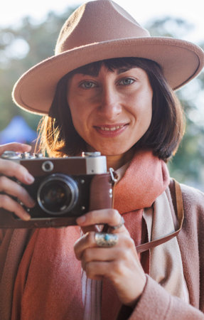 young woman with a film camera. Hipster tourist woman with camera. the girl takes photographs with a...