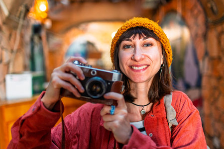 Young beautiful smiling hipster woman in fashionable clothes with camera. Carefree woman with...