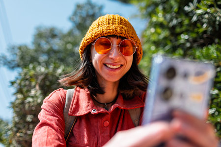 Woman taking photos on the street with a mobile phone. Stylish girl with a phone, tourist in the...