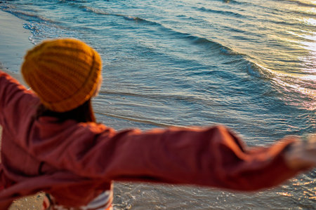 Happy cheerful girl having fun on the beach. Attractive woman running on the beach waving her arms....