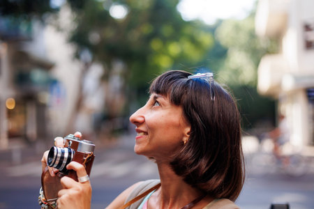 Girl walking around the city and taking pictures with a camera. young girl with a film camera in the...