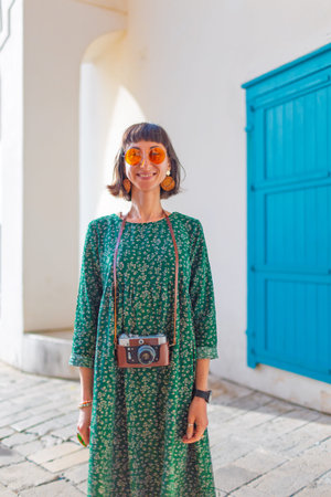 A girl with a camera walks around the city. A tourist enjoys her vacation. A travel blogger takes...