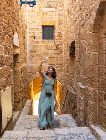 A young girl in a dress and hat walks in the old town. The girl looks at the sights.の写真素材