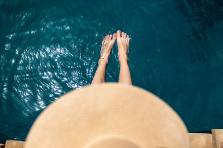 summer mood. Beautiful slender legs of a woman relax in the water enjoying a summer tan, a woman in...