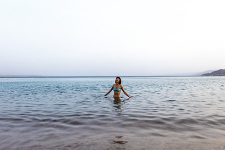 Girl relaxing and swimming in the waters of the Red Sea in Israel. Summer seascape with a girl. Travel and vacation.の写真素材
