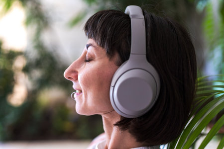 Portrait of woman listening to music on headphones, young woman listening to songs and enjoying music.の写真素材