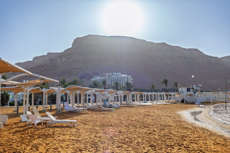 View from the beach to the beautiful Dead Sea resort. Sun loungers and umbrellas on the beach near the hotel. vacation in Israel. dead sea. Israelの写真素材