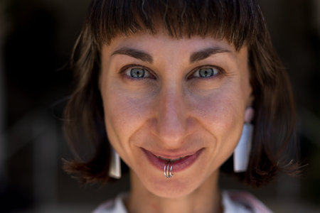 girl portrait European brunette, close-up portrait. Stylish hippie girl wears piercing ring. Woman...