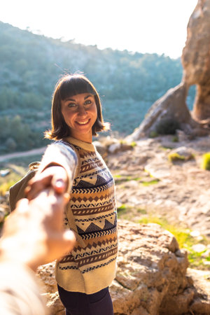 follow me. happy couple traveling. portrait of happy female tourist in mountains. girl smiling. trekking and hiking. sport and healthy lifestyle concept. girl with backpack.の写真素材