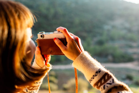 happy woman in the mountains with a camera in her hands. girl relaxing and taking photos in the...
