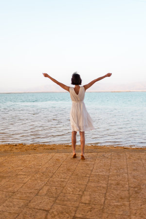 Girl enjoying her vacation at the Dead Sea. Thalasso woman enjoying a quiet walk on the Dead Sea beach. Israel.の写真素材