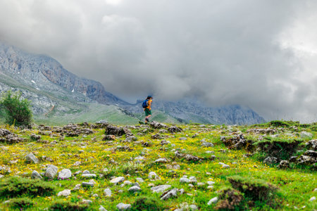 Traveling child. a tourist with a backpack walks along a mountain road. hiking and active healthy lifestyle. adventure holidays with children.の写真素材
