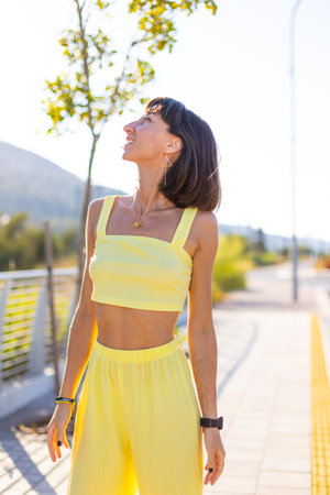 Close-up portrait of a girl. Seductive carefree woman posing outdoors on a sunny day. Young beautiful smiling brunette with facial piercing in fashionable summer clothes. Cheerful and happy.の写真素材