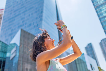 Creating a social media contact. girl with a camera against the backdrop of modern buildings....