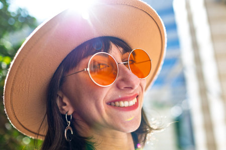 Young beautiful smiling woman in fashionable clothes and hat. Carefree model posing outdoors on a...