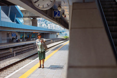 girl looking at watch. girl standing at train station waiting for train. woman with backpack waiting...