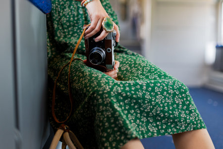 girl holds camera in hands. stylish girl with camera in hands enjoys train ride. Train travel. Enjoy...