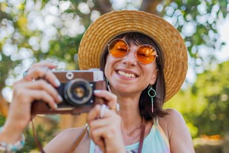 Portrait of a stylish young tourist, with a camera on the street. Stylish girl with a film camera travels. Girl with a camera.の写真素材