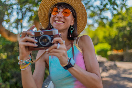 Charming woman with camera on the street. Portrait of a beautiful girl smiling on the street....