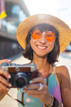 Woman photographer with camera. Young girl photographer aims the lens and enjoys the process of...