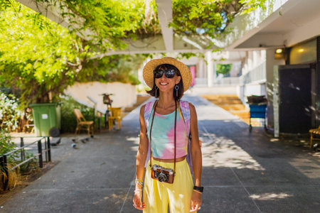 Stylish woman with a camera on the street. Portrait of a beautiful girl smiling on the street....